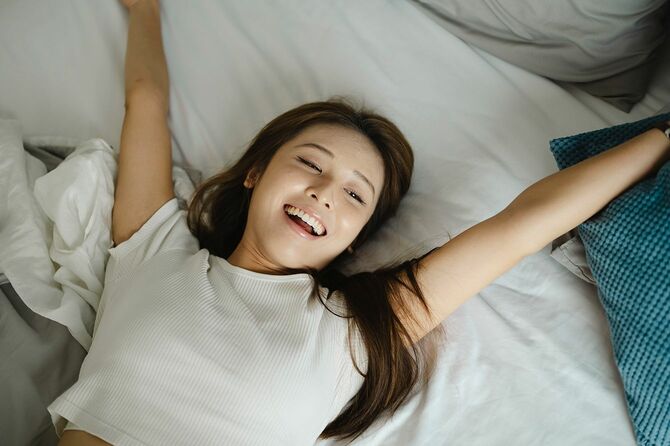 きれいなシーツの上でゆっくり休む女性