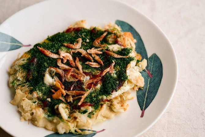 お昼ご飯。キャベツ、豚コマ少し、桜エビと青海苔をたっぷりかけたお好み焼き。お昼はうどん、パスタなど麺類も多い。約80～100円