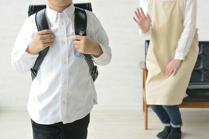 学校に行く少年と見送る母
