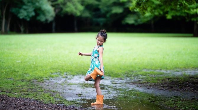 レインブーツを着て公園で遊んでいる女の子