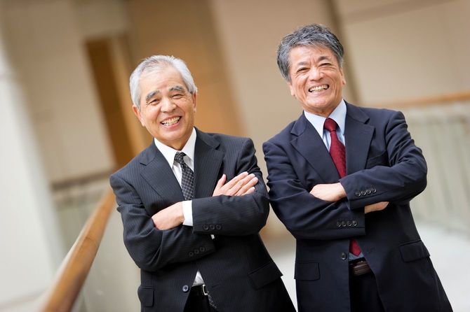 腕を組んで、笑顔を見せる二人のシニア男性
