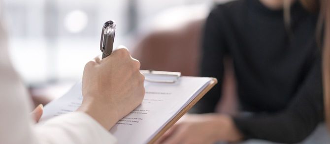 メモを取りながら問診を進める医師