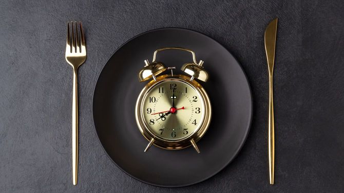 金色のナイフとフォーク、黒いプレートには黄金の目覚まし時計