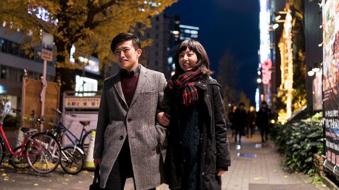 笑顔で夜道を歩くカップル