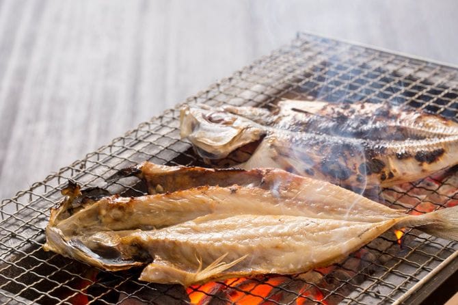 魚の開きを炭火で焼いている