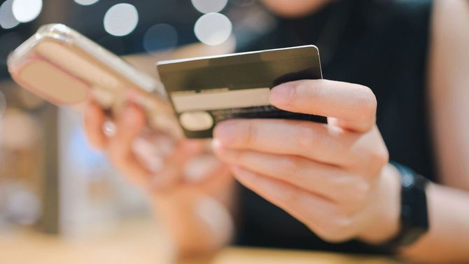 スマホとクレジットカードを持つ手