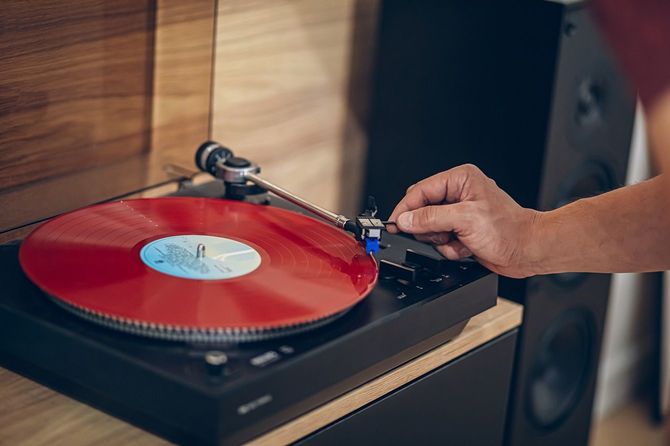レコードプレーヤーでレコードを再生する人