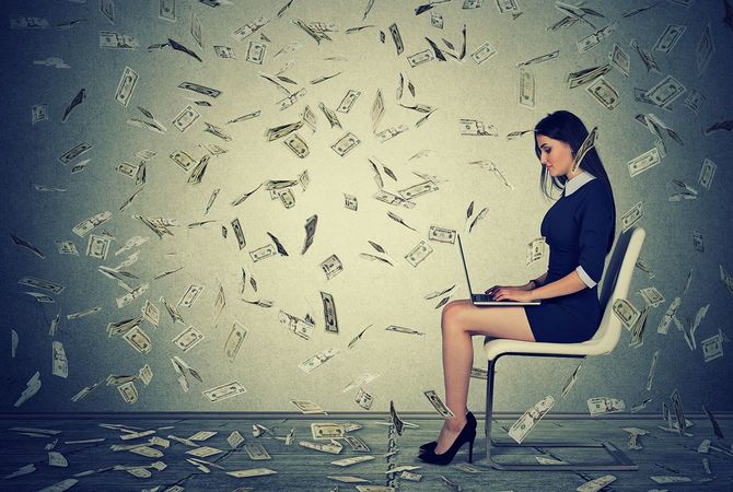 椅子に座ってラップトップを使用して成功した若い女性