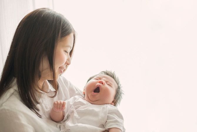 陽だまりの中であかちゃんと楽しい時間を過ごす母親