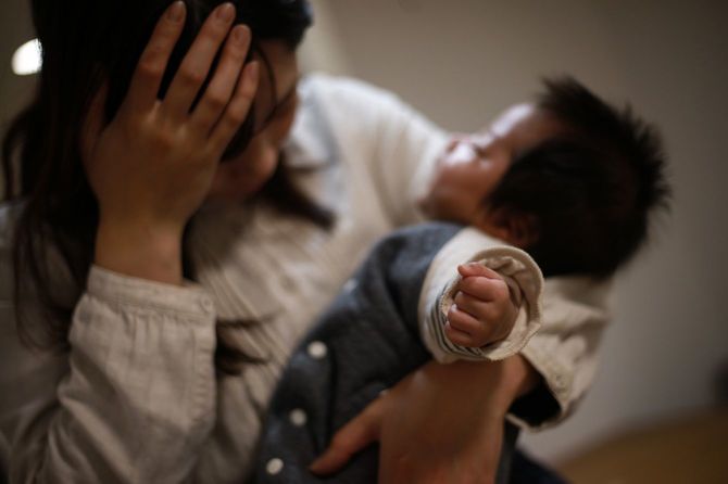 赤ちゃんを抱いて悩む女性