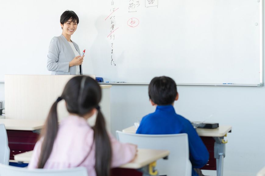 教室で子供に授業をする教師