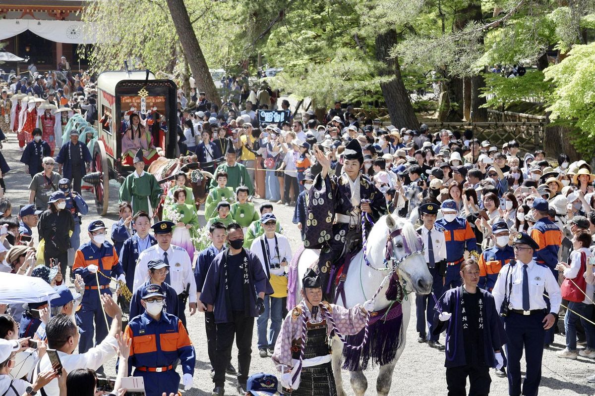 「源義経公東下り行列」で白馬にまたがり、手を振る源義経役の寺田心さん＝2024年5月3日午後、岩手県平泉町