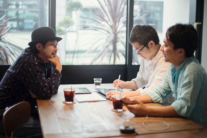 カフェで仕事の打ち合わせをする3人の男性