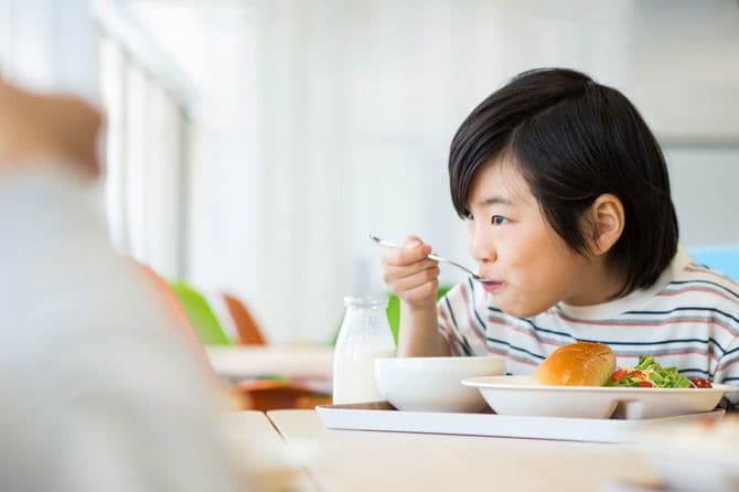 給食を食べる小学生