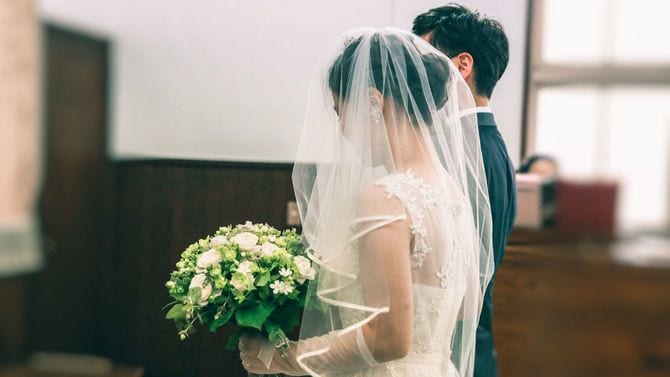 チャペルで挙式する新郎新婦