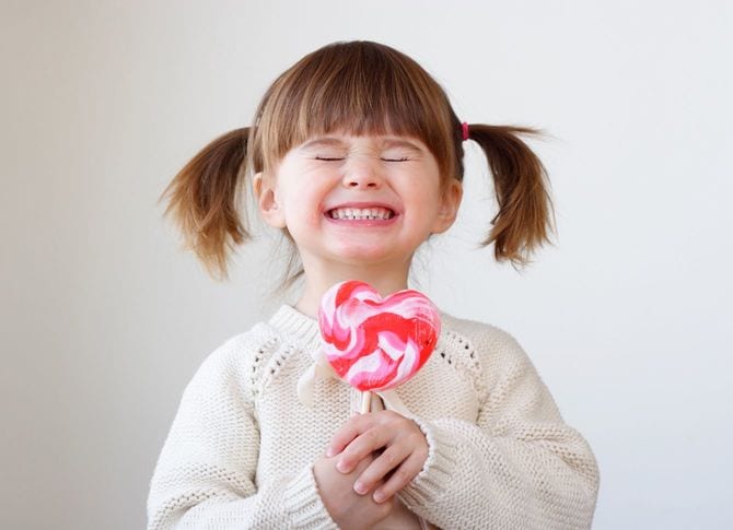 大きなキャンディを手にうれしそうな少女