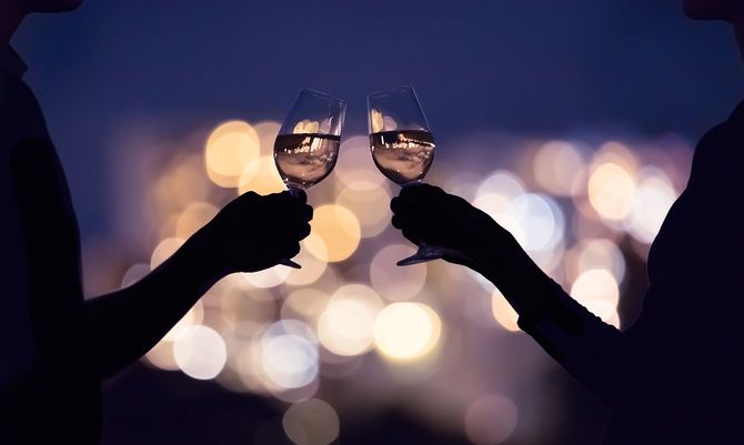夜に街でワインを楽しむカップル