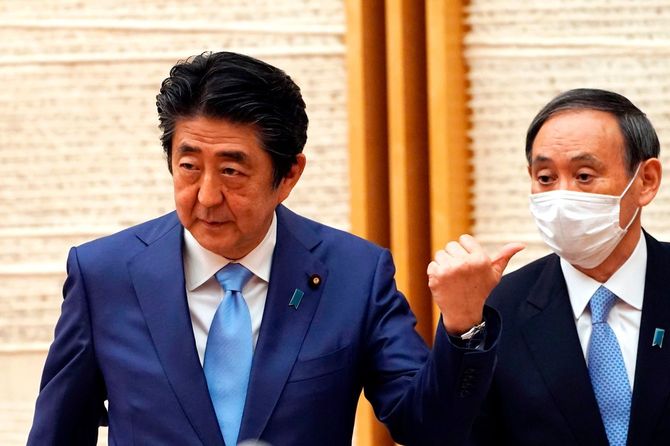 菅義偉官房長官の隣でジェスチャーをする安倍晋三首相(左)=2020年5月4日、首相官邸
