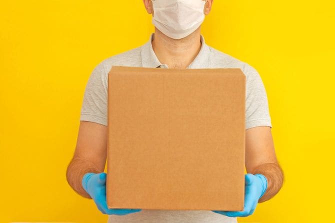 段ボール箱を持っている配達員