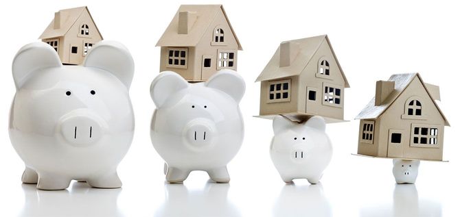 家の模型を上に載せている4つの貯金箱