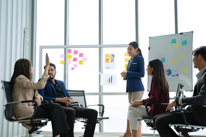 会議で挙手をする女性