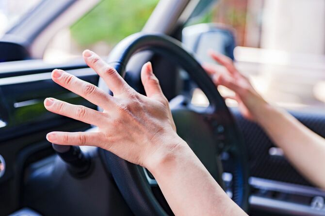 ハンドルから手を放す運転手