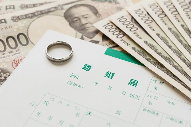 離婚届の上に置かれた結婚指輪と、周りにはたくさんの新札