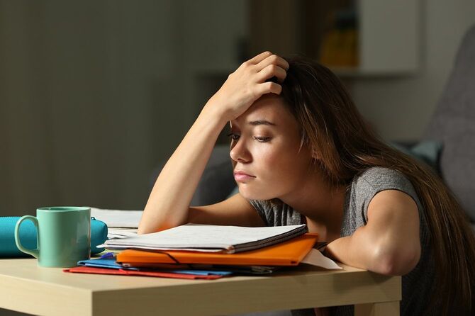 夜勉強しようとして疲れている学生