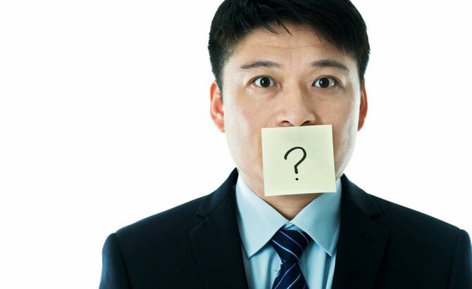 口に疑問符がついたビジネスマン