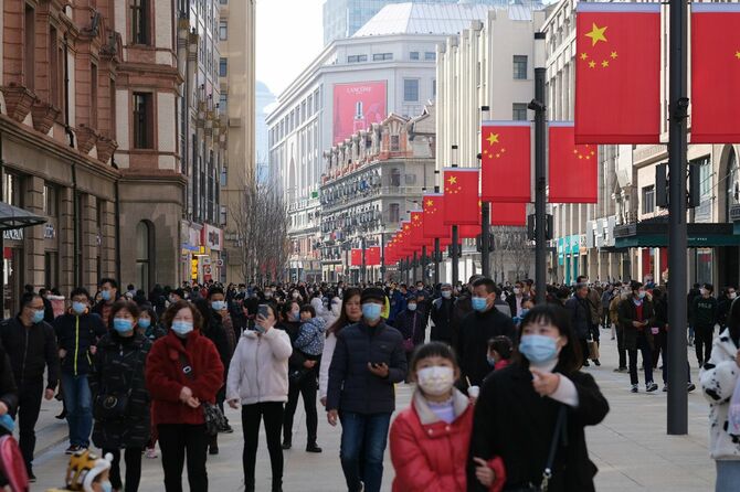 2021年2月、コロナウイルスを防ぐためにフェイスマスクを着用し、混雑した南京路を歩く人々