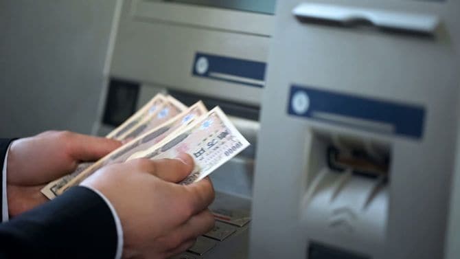 ATMの前で現金を数える手元