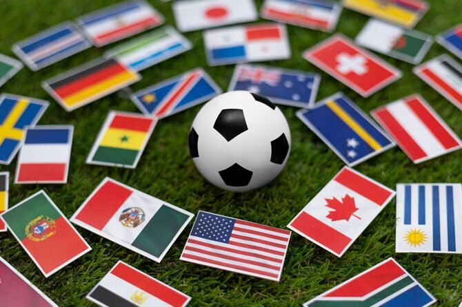 芝生に国際旗が掲げられたサッカーボール