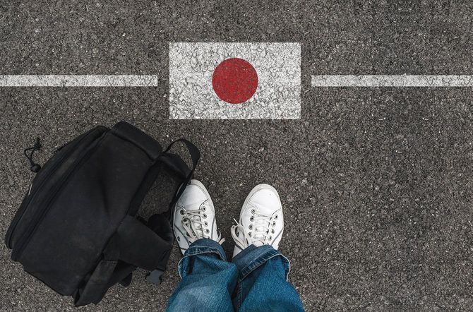 日本の国旗が描かれた道路に立つ人の足元
