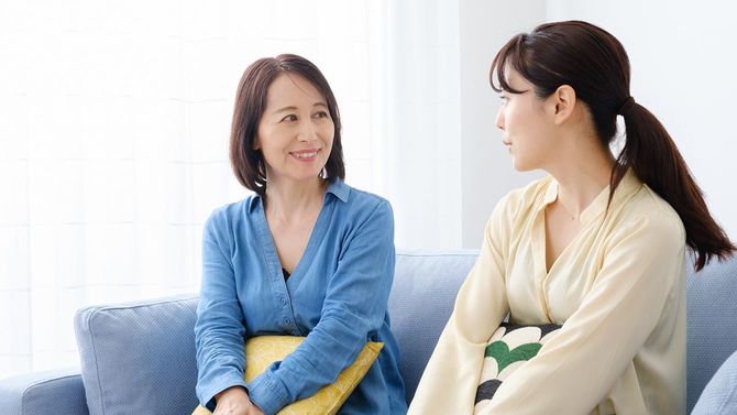 リビングルームでリラックスアジアの母と娘