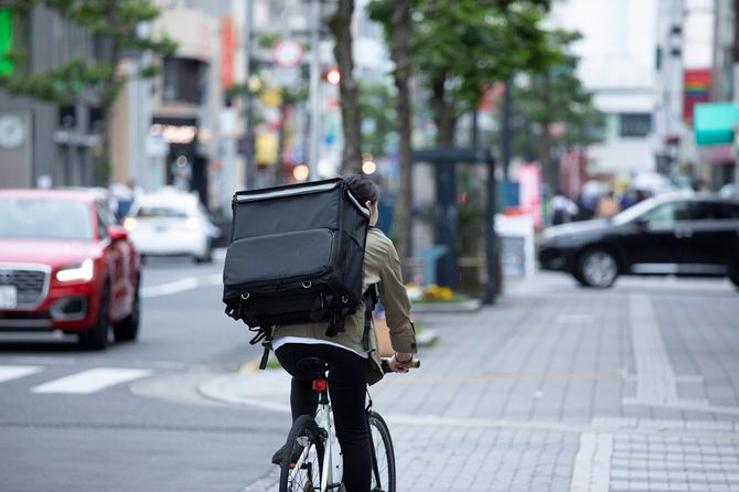 自転車で荷物を配達している若い女性