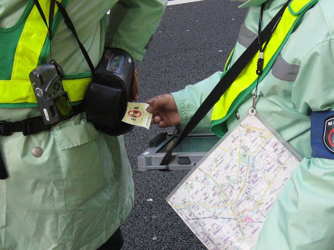 駐禁ステッカーを発行する駐車監視員