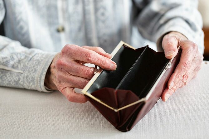 90歳の先輩女性の手、空の財布を持つ