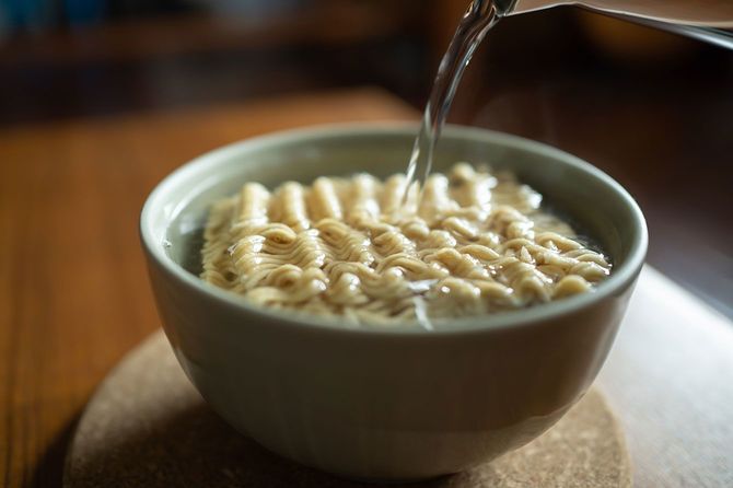 インスタントラーメンにお湯を注ぐ様子