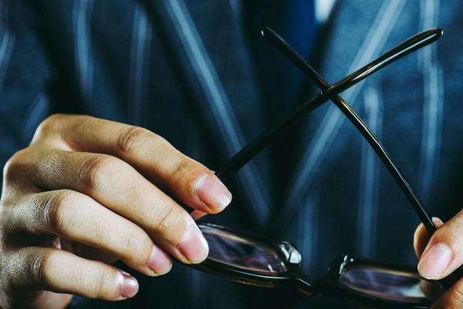 メガネを外す人の手元