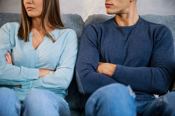 腕を組んで座っているカップル