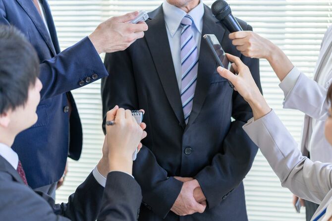 マスメディアの取材を受けている男
