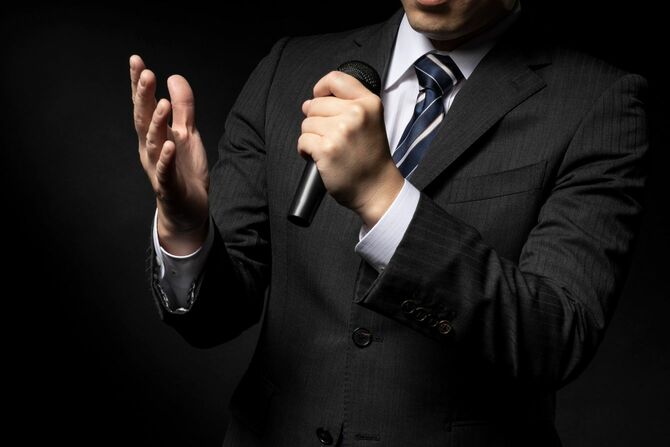 マイクで話す男性