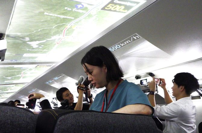 時速500キロのプロジェクションを撮影する記者たち