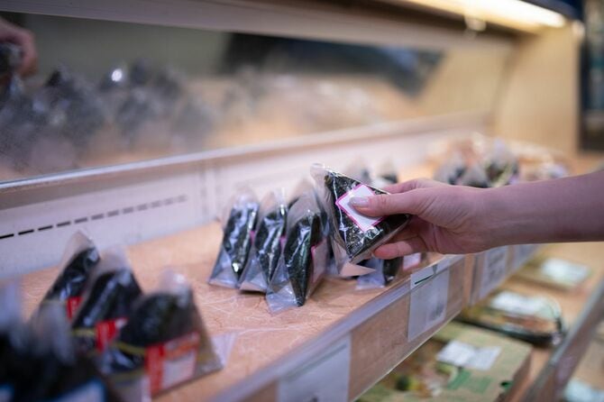 おにぎりを選ぶ買い物客の手