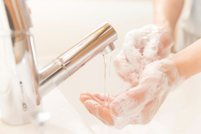 石鹸で手を洗う男