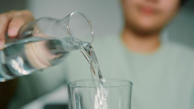 グラスに水を注ぐアジア人女性