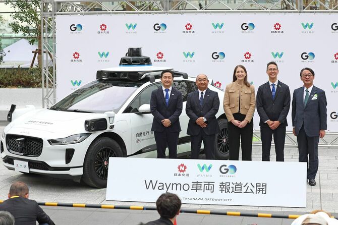 ウェイモの自動運転車両を公開し、撮影に応じる（左から）GOの中島宏社長、日本交通の若林泰治社長、ウェイモのニコール・ガベル氏、日本交通取締役兼GO会長の川鍋一朗氏、JR東日本の喜勢陽一社長＝2025年4月10日、東京都港区