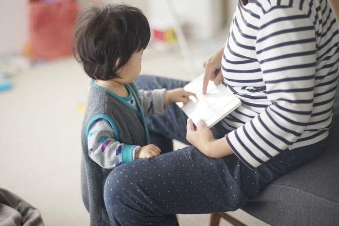 母と男の子が自宅で絵本を読む