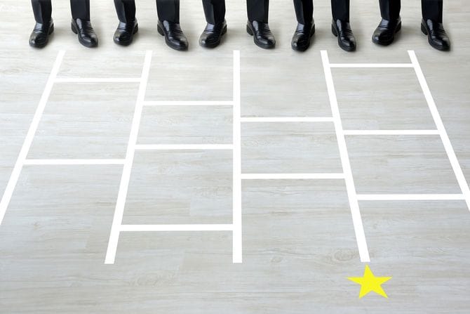 あみだくじのそばに立つビジネスマン