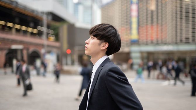 駅前広場で誰かを待つ男性